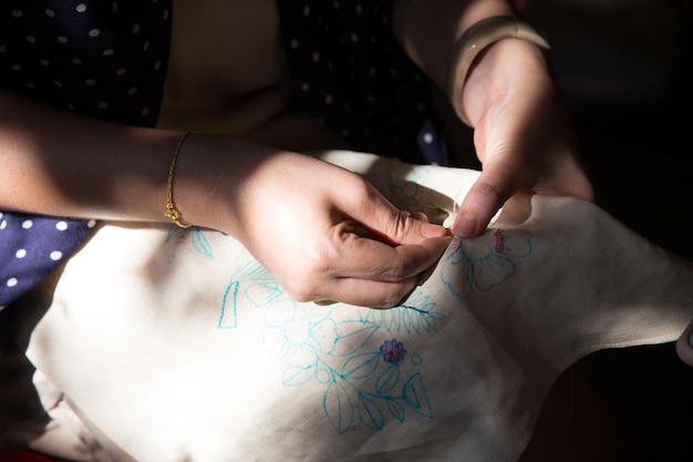 mână care coase detaliu